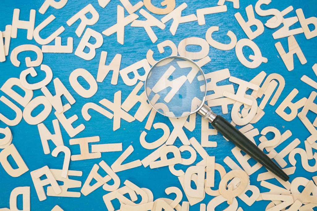 Magnifying glass looking at letters