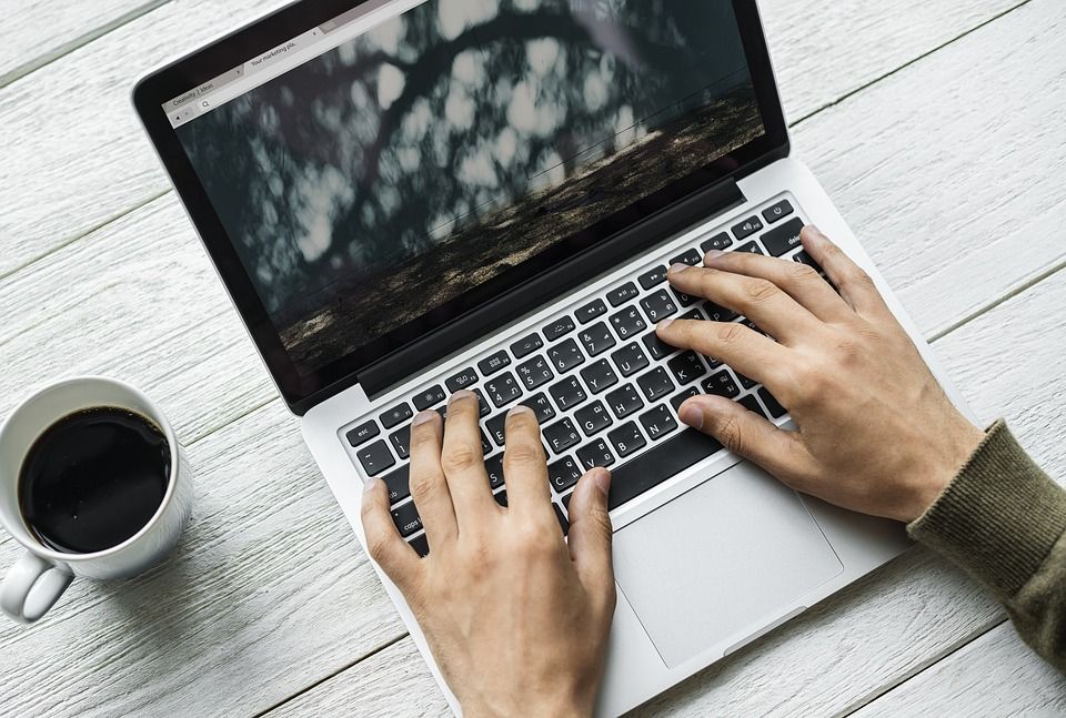 Person using a laptop with coffee