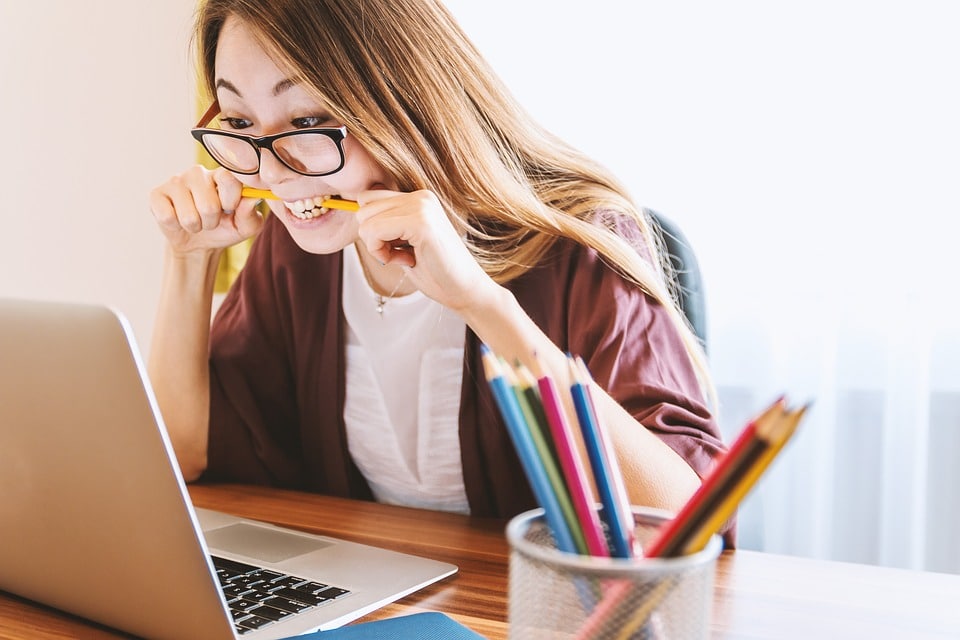 Girl biting pencil reading negative reviews