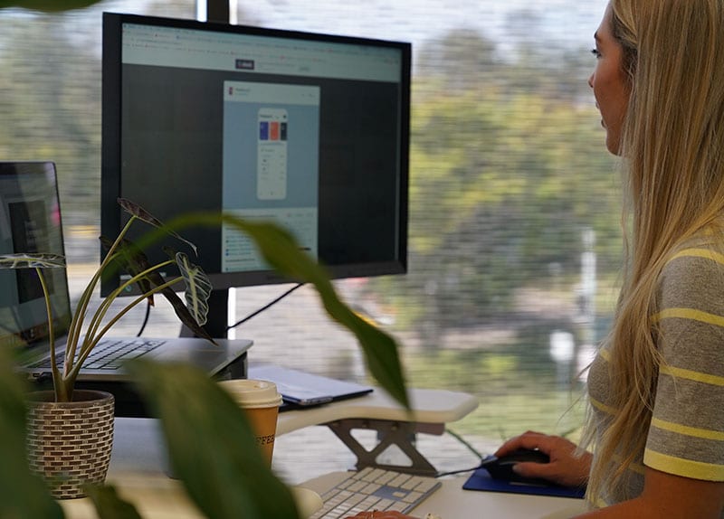 woman qa testing website on large desktop screen
