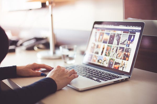 person using laptop with images